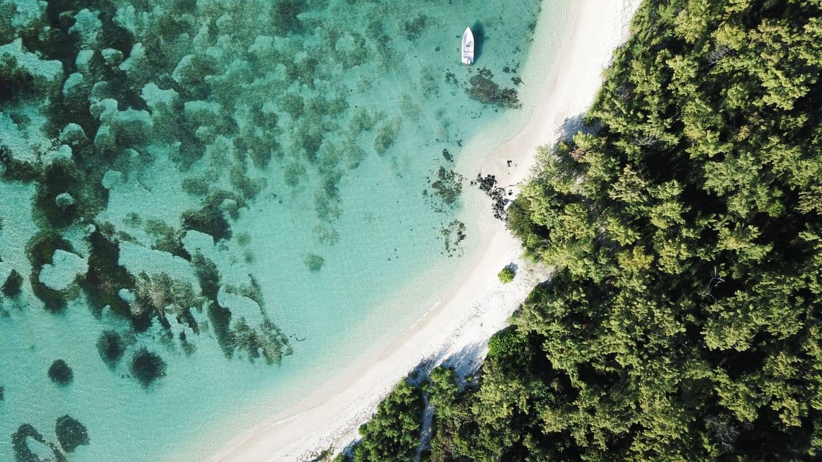 A sweeping aerial view of the majestic Le Morne Brabant mountain surrounded by the turquoise waters of the Indian Ocean in Mauritius.