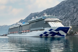 image features the Sky Princess docked in calm waters with a mountainous landscape in the background