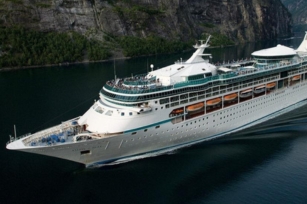 image of the Vision of the Seas cruise ship cruising along the calm blue green seas